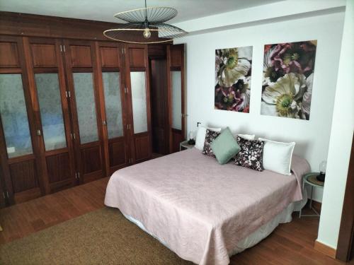 a bedroom with a bed and wooden cabinets at Villa Tahoyo - Disfruta con la familia en un entorno tranquilo in Máguez