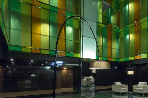 een lobby met een kleurrijke glas-in-loodmuur bij Le Meridien Panama in Panama-Stad