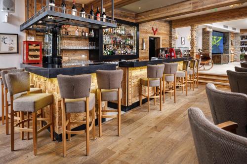 a bar at a restaurant with wooden floors and bar stools at Teleferic Grand Hotel in Poiana Brasov