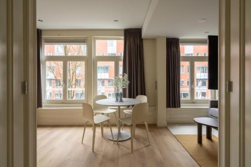 a dining room with a table and chairs and windows at Numa Amsterdam Oosterpark in Amsterdam