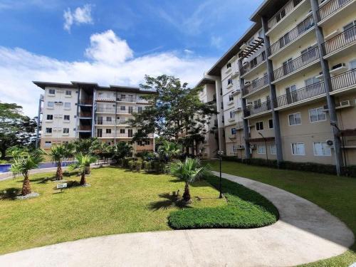 ein großes Apartmenthaus mit einem Park davor in der Unterkunft Amaia Steps Nuvali fully furnished unit with swimming pool view near Carmelray Pitland in Calamba