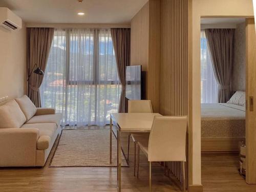 een slaapkamer met een bed, een tafel en een bank bij 2 Bedroom Skypark Condo Laguna in Bang Tao Beach