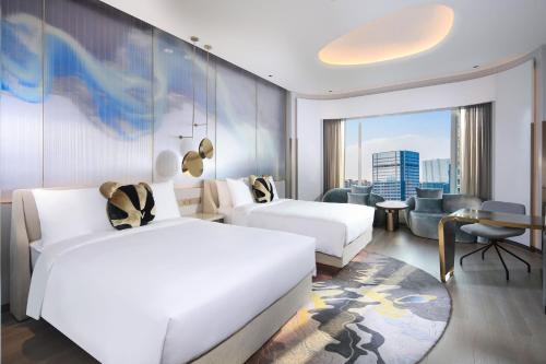 a hotel room with two beds and a living room at W Chengdu in Chengdu
