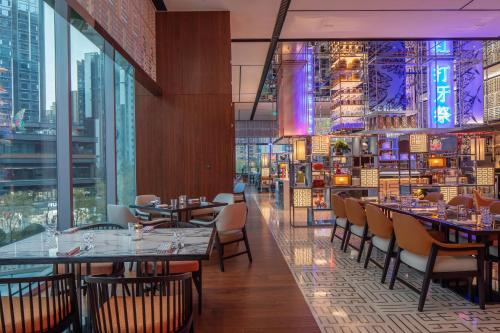 a restaurant with tables and chairs and a view of a city at W Chengdu in Chengdu