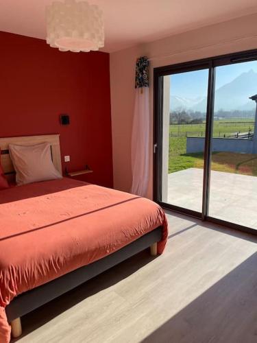 - une chambre avec un lit et une grande porte coulissante en verre dans l'établissement Maison au cœur des Pyrénées !, à Ayzac-Ost