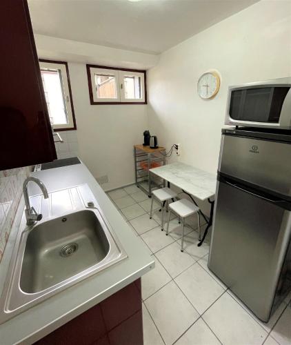 a kitchen with a sink and a refrigerator and a table at Réf 531, Seignosse Océan, Appartement proche de la plage et du centre, 4 personnes in Seignosse