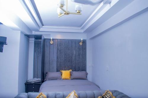 a bedroom with a bed and a ceiling at Superb High spec Studios . Kabete. 15 Mins from Westlands in Nairobi