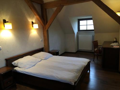 a bedroom with a bed and a desk and a window at Folwark Polski in Ostrów Wielkopolski
