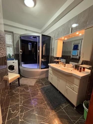 a bathroom with a large sink and a large mirror at PlatánWood ComfortHome in Zalaegerszeg