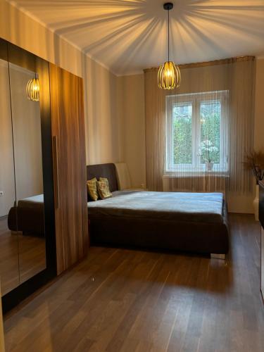 a bedroom with a large bed and a window at PlatánWood ComfortHome in Zalaegerszeg