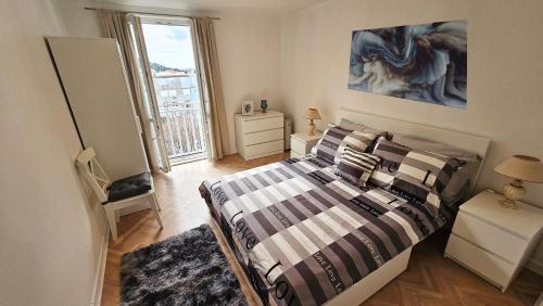 ein Schlafzimmer mit einem Bett mit gestreifter Bettwäsche und einem Fenster in der Unterkunft Bridge View Apartment Lapad in Dubrovnik