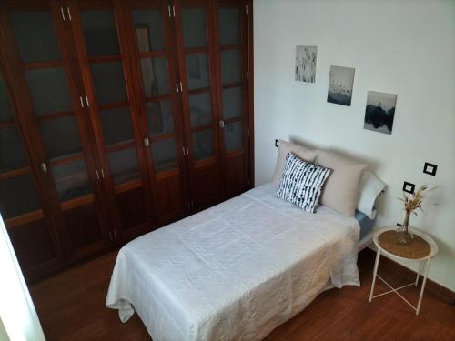 a small bedroom with a bed and a table at Villa Tahoyo - Disfruta con la familia en un entorno tranquilo in Máguez