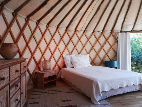 a bedroom in a yurt with a bed and a window at Yourte au coeur du village in Fontvieille