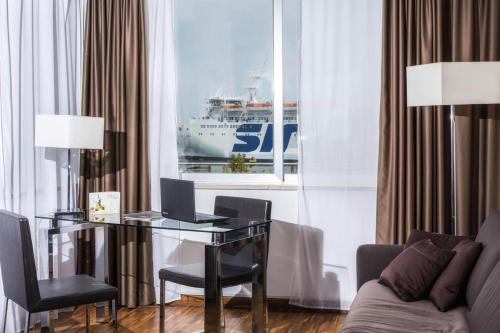 a room with a desk with a computer and a cruise ship at Hotel La Bussola in Milazzo