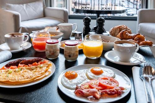 una mesa de desayuno con alimentos y bebidas para el desayuno. en Le Metropolitan, Paris Tour Eiffel, a Tribute Portfolio Hotel, en París