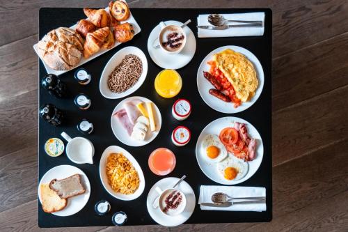 una mesa con platos de comida para el desayuno. en Le Metropolitan, Paris Tour Eiffel, a Tribute Portfolio Hotel, en París