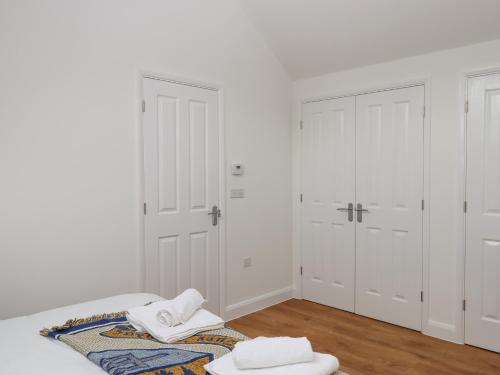 a white bedroom with two towels on a bed at Narracott Down in South Molton