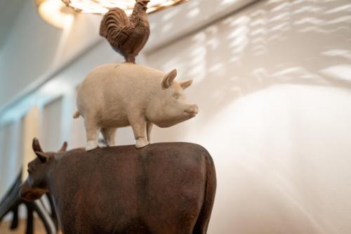 una estatua de un cerdo y un pollo sobre una mesa en Kleiner Storch - Seehotel Dümmer, en Hüde