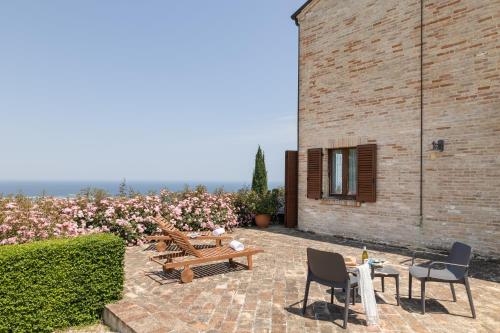a patio with tables and chairs next to a brick building at Villa Cri Cri B&B di Charme in San Benedetto del Tronto