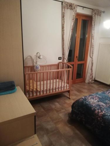a room with a crib and a bedroom with a door at Il Rifugio Della Luna in Castel Ritaldi