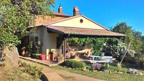 a house with a porch with a swing at Il Mandorlino Pitigliano appartamento in tipico casale maremmano con portico e giardino in Pitigliano