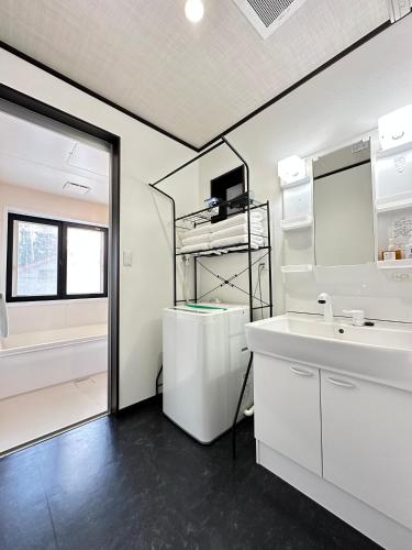a white bathroom with a sink and a tub at 72 Mt View - B棟 - in Fujikawaguchiko