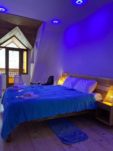 1 dormitorio con 1 cama grande con iluminación púrpura en CELENTANO, en Dilijan