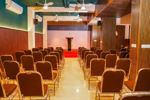 a room with rows of chairs and a stage at Palcastle Regency in Palakkad