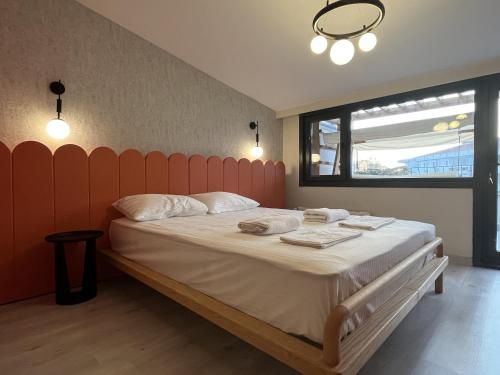 een slaapkamer met een groot bed met een oranje hoofdeinde bij Stylish Seaview Flat in Ortaköy Daire 13 in Istanbul