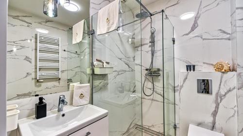 a bathroom with a shower and a sink at Apartamenty z basenem i saunami STONE HILL RESORT II VIP Centrum by Royal Aparts in Szklarska Poręba