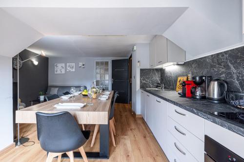 une cuisine avec des armoires blanches et un comptoir en bois dans l'établissement 3 pièces des Jardins parking clim 1 min plage, à Menton