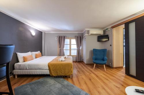 une chambre d'hôtel avec un lit et une chaise bleue dans l'établissement 3 pièces des Jardins parking clim 1 min plage, à Menton