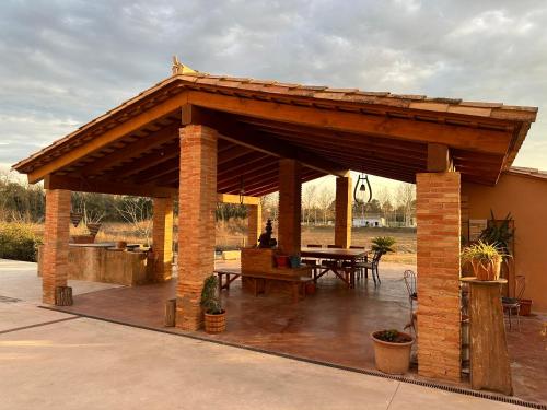 - un pavillon en bois avec une table de pique-nique et une table dans l'établissement El Molí de Fornells, à Fornells de la Selva