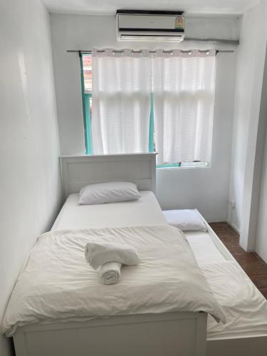 een wit bed met een handdoek erop in een slaapkamer bij Le Moon Hotel in Chiang Khan