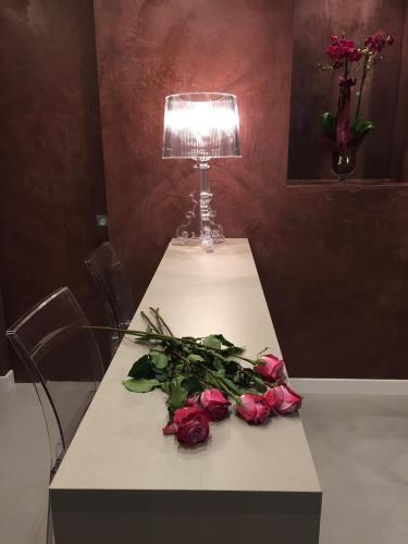 a table with flowers and a lamp on it at L'Angolino Nascosto in Verona