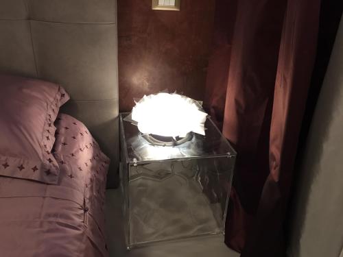 a table with a lamp on it next to a bed at L'Angolino Nascosto in Verona