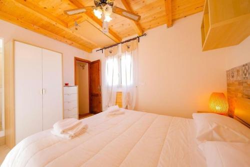 een slaapkamer met een wit bed en een houten plafond bij Tower Sea View in Cefalù