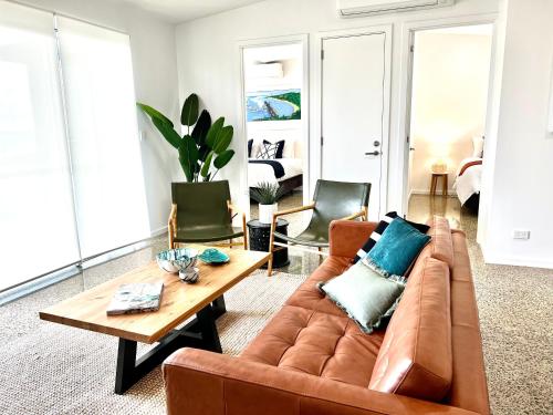 a living room with a brown couch and a table at Wild Retreat - Luxury Home with Magnificent Views in Vivonne Bay