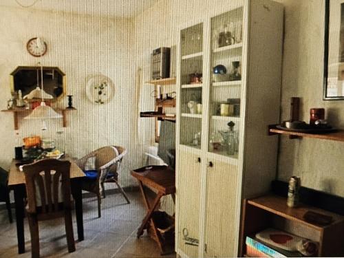 uma cozinha e sala de jantar com um armário branco em Micha's Kuca em Porec