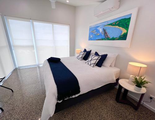 a bedroom with a large bed and a painting on the wall at Wild Retreat - Luxury Home with Magnificent Views in Vivonne Bay