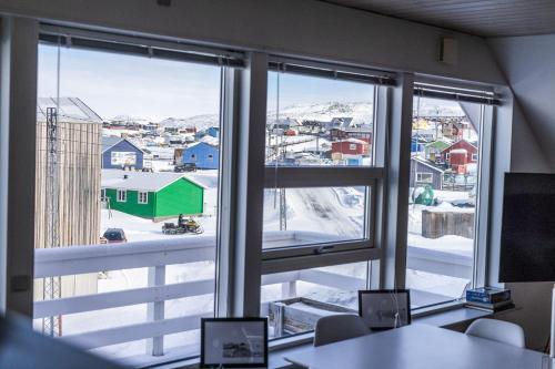 an office with a view of a city from a window at Ilulissat Stay - 4-bedroom villa with sea view and hot tub in Ilulissat