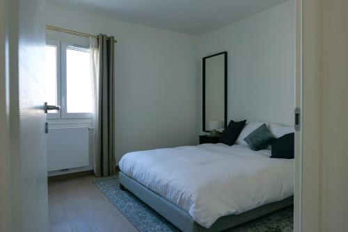 une chambre blanche avec un lit et une fenêtre dans l'établissement LE PARADIS BLANC, à Annecy