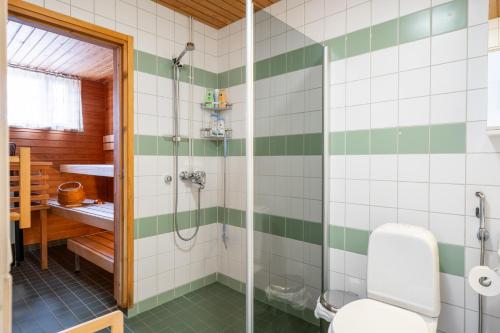 a bathroom with a shower with green and white tiles at Very nice apartment, 1BR, Private Sauna, Ocean view from balcony in Helsinki