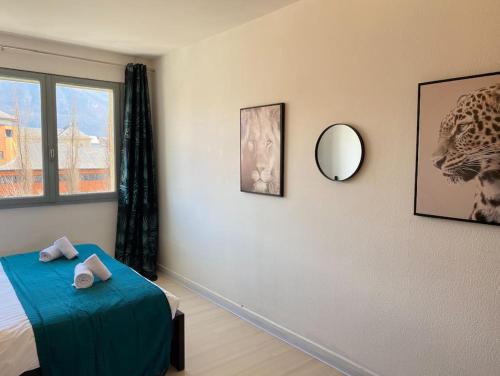 une chambre avec un lit et un miroir au mur dans l'établissement Amazone, centre-ville & parking, à Annecy