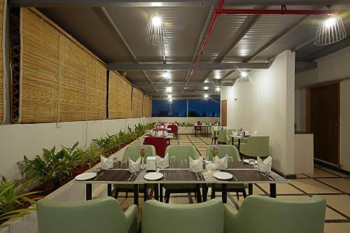 a restaurant with tables and chairs in a room at Grand Continent Malleshwaram A Sarovar Portico Affiliate Hotel in Bengaluru
