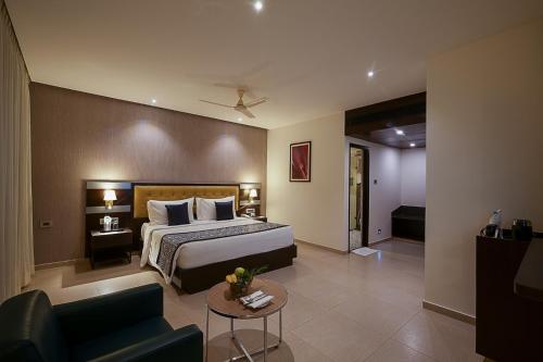 a hotel room with a bed and a couch at Grand Continent Malleshwaram A Sarovar Portico Affiliate Hotel in Bengaluru