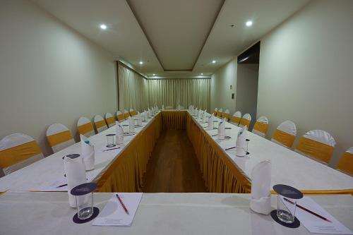 a conference room with a long table and chairs at Grand Continent Malleshwaram A Sarovar Portico Affiliate Hotel in Bengaluru