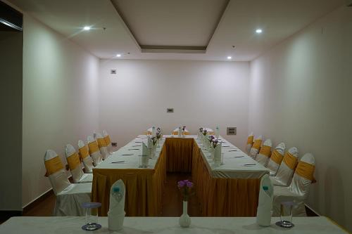a conference room with a long table and chairs at Grand Continent Malleshwaram A Sarovar Portico Affiliate Hotel in Bengaluru