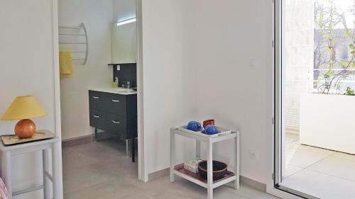 - une cuisine avec un lavabo et un miroir dans la chambre dans l'établissement Appartement Centre ville Beaux Arts 2 personnes calme et confort, à Montpellier