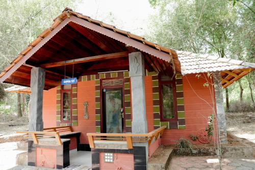 ein kleines Haus mit einer Bank davor in der Unterkunft Misty Night Jungle Side Resort in Pulpally